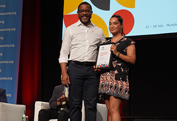 Manisha Dhakal accepts the Elizabeth Taylor Human Rights Award on the plenary stage at AIDS 2024 alongside The Elizabeth Taylor AIDS Foundation's Robert Suttle